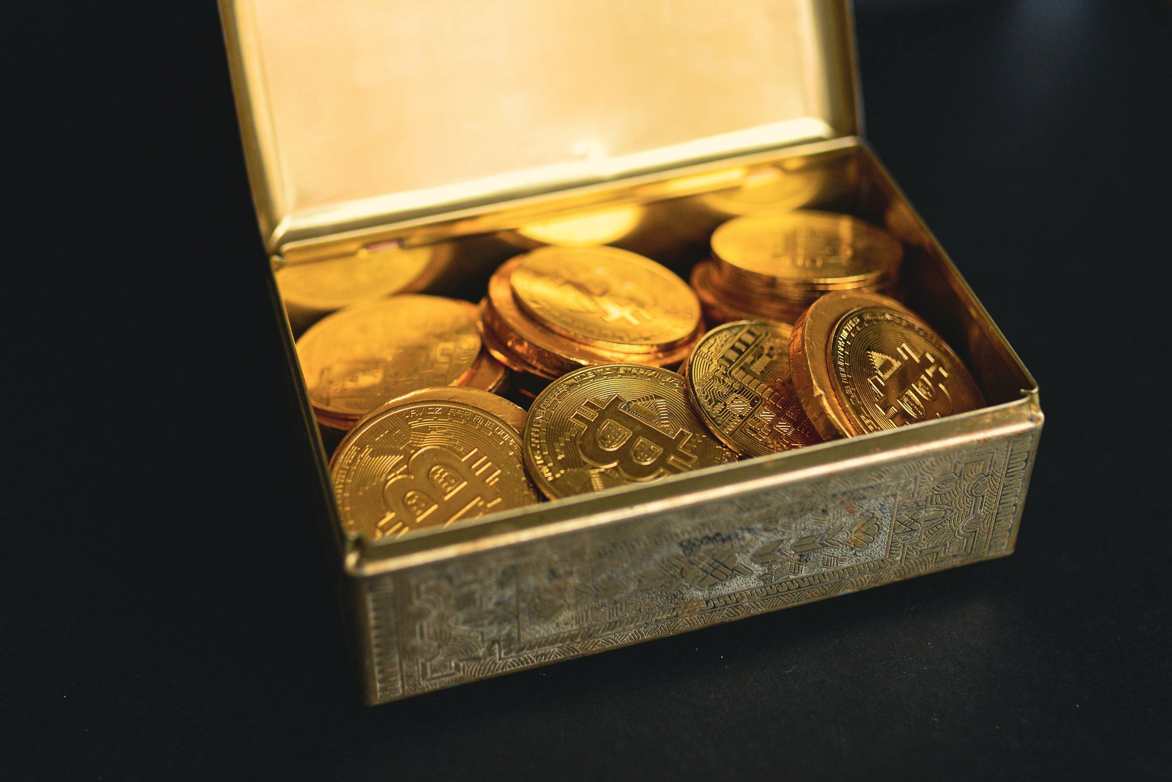 Geöffnete goldene Dose voller Bitcoin-Sammlermünzen